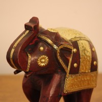 Elephant Showpiece with Brass Art Styled on Table Burgundy wooden elephant showpiece with brass art placed on a wooden table as a shelf or console accent.
