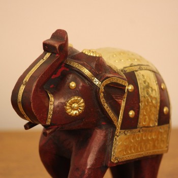 Elephant Showpiece with Brass Art Styled on Table Burgundy wooden elephant showpiece with brass art placed on a wooden table as a shelf or console accent.