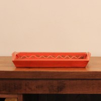 Coral-coloured rectangular tray featuring colourful geometric patterns and traditional floral artwork.