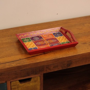 Hand Painted Red Patchwork Tray – Large Large wooden serving tray in red, hand painted in a colourful patchwork pattern of floral and geometric motifs in green, blue, and yellow, with cut-out side handles.