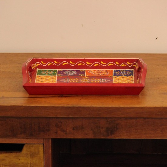 Hand Painted Red Patchwork Tray – Medium Medium wooden serving tray in red, hand painted in a colourful patchwork pattern of floral and geometric motifs in green, blue, and yellow, with cut-out side handles.