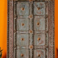 Blue green handcrafted wooden door wall panel with carved detailing and antique metal studs for rustic Indian wall decor