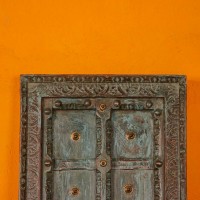 Blue green handcrafted wooden door wall panel with carved detailing and antique metal studs for rustic Indian wall decor