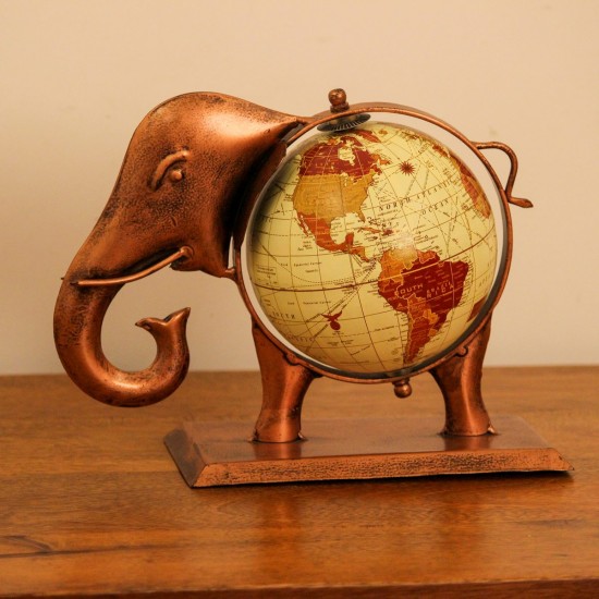 Copper finish elephant globe styled on a wooden desk as statement desk décor