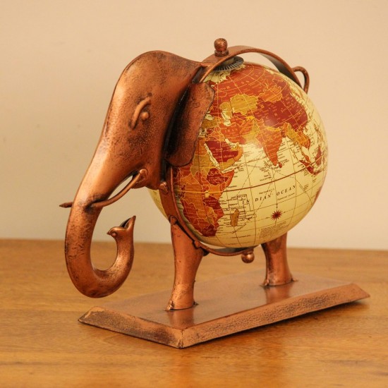 Copper finish elephant globe styled on a wooden desk as statement desk décor
