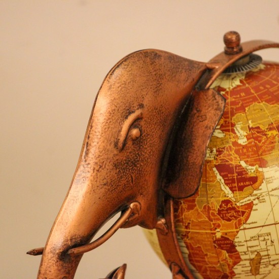 Copper finish elephant globe styled on a wooden desk as statement desk décor