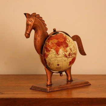 Copper finish horse globe styled on a wooden desk as statement desk décor