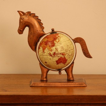 Copper finish horse globe styled on a wooden desk as statement desk décor