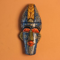 Hand-carved wooden tribal face mask hand painted in blue with a mustard-yellow crown, red eyes and lips, and fine white floral detailing across the face.
