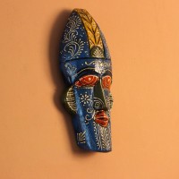 Hand-carved wooden tribal face mask hand painted in blue with a mustard-yellow crown, red eyes and lips, and fine white floral detailing across the face.