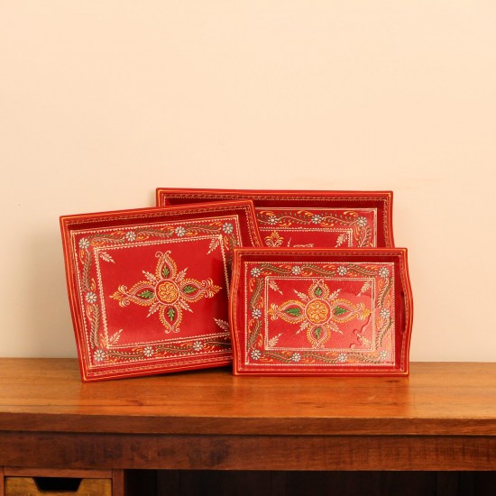 Front view of a set of three hand-painted red wooden serving trays in small, medium and large sizes