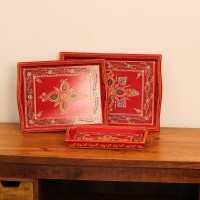 Front view of a set of three hand-painted red wooden serving trays in small, medium and large sizes