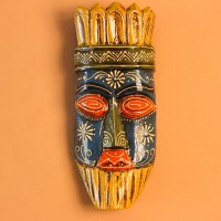 Hand Painted Tribal Face Mask – Blue & Yellow Hand-carved wooden tribal face mask hand painted in blue with red eyes and lips, a fringed mustard-yellow crown, a geometric zigzag forehead band, and white floral detailing across the face.
