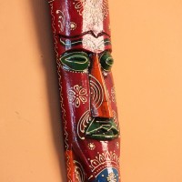 Hand Painted Tribal Face Mask – Maroon Mandala Hand-carved wooden tribal face mask in an elongated form, hand painted in maroon with a mandala-bordered crown, green eyes, and fine white floral detailing.