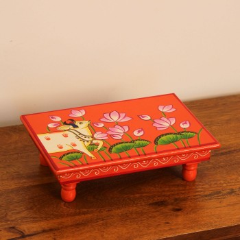 Large wooden chowki hand painted in Pichwai style, featuring a cow standing amid blooming pink lotus flowers on a vivid red base, edged with a plain wooden border.