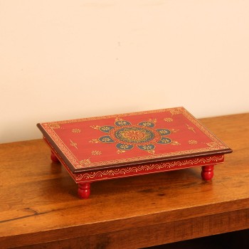 Large wooden chowki hand painted in red with a detailed mandala centrepiece in blue and gold, bordered by fine floral and paisley motifs along the edges.