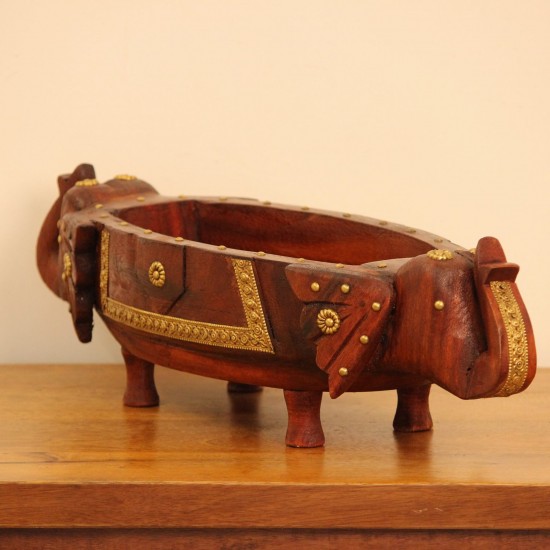 Two Elephant Head Fruit Bowl Styled on Table Brown polish wooden elephant head fruit bowl with brass detailing placed on a wooden table as a dining or console centrepiece.