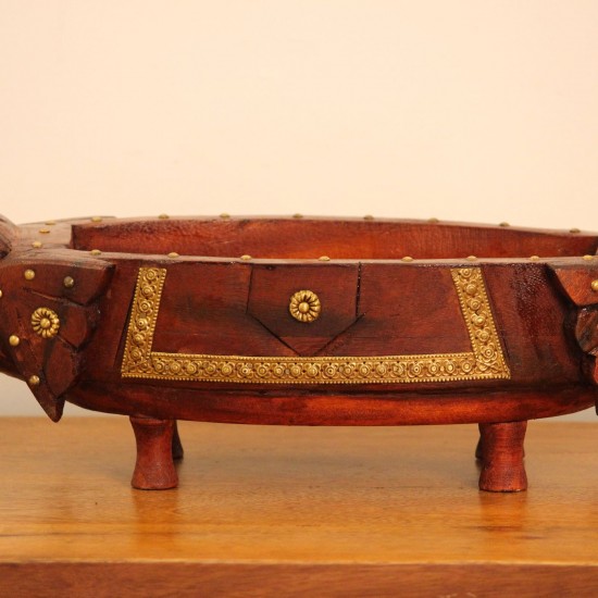 Two Elephant Head Fruit Bowl Styled on Table Brown polish wooden elephant head fruit bowl with brass detailing placed on a wooden table as a dining or console centrepiece.