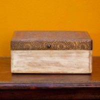 Distressed white wooden box with brass embossed top