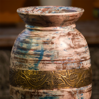 Colourful distressed wooden matka with embossed brass work – rustic wooden décor pot front view Colourful distressed wooden matka with embossed brass work – rustic wooden décor pot front view