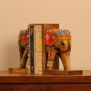A pair of wooden elephant-shaped bookends, hand painted in red, blue, and yellow folk-art patterns, mounted on flat wooden bases to hold books upright.