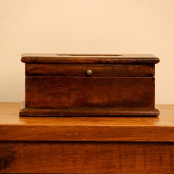 Natural Dark Polish Wooden Tissue Box – Angled View Angled view of a wooden tissue box in a dark natural polish, with an oval dispensing cut-out on the lid and a small brass knob on the front.