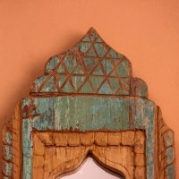 Jharokha Mirror Frame – Green, Styled on Wall Small 13 inch green distressed jharokha mirror frame mounted on an orange wall as a colourful entryway accent.