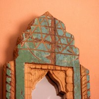 Jharokha Mirror Frame – Rustic Green, Front View Front view of a hand-carved wooden mirror frame in a jharokha arch shape, in weathered green with chipped paint, a lattice-carved crown and an arched mirror at the centre.