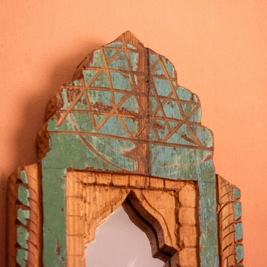 Jharokha Mirror Frame – Rustic Green, Front View Front view of a hand-carved wooden mirror frame in a jharokha arch shape, in weathered green with chipped paint, a lattice-carved crown and an arched mirror at the centre.