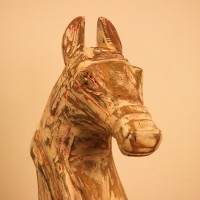 Rustic Pink Horse Head Sculpture Styled on Console Rustic pink-streaked wooden horse head sculpture on a stand, styled on a wooden console as a tabletop accent.