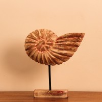 Carved Wooden Ammonite Shell Sculpture Hand-carved wooden sculpture shaped after a spiral ammonite fossil, showing ridged chamber detailing along its curve, mounted upright on a compact stand.