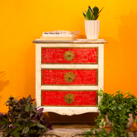 White and red wooden bedside drawer with embossed brass detailing front view White and red wooden bedside drawer with embossed brass detailing front view