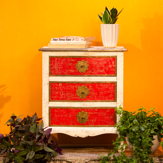 White and red wooden bedside drawer with embossed brass detailing front view White and red wooden bedside drawer with embossed brass detailing front view