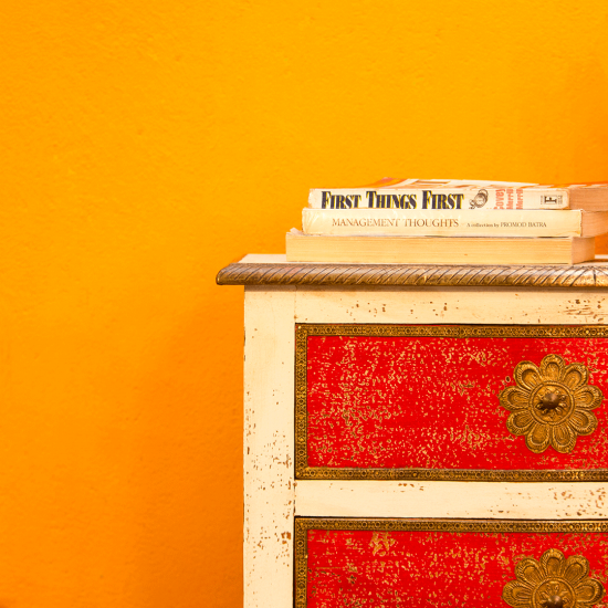 White and red wooden bedside drawer with embossed brass detailing front view White and red wooden bedside drawer with embossed brass detailing front view