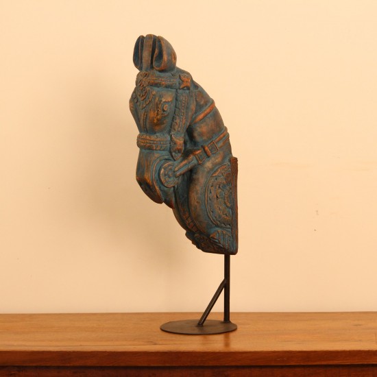 Blue distressed carved wooden horse on stand styled on a wooden table as table décor