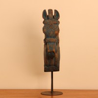 Blue distressed carved wooden horse on stand styled on a wooden table as table décor