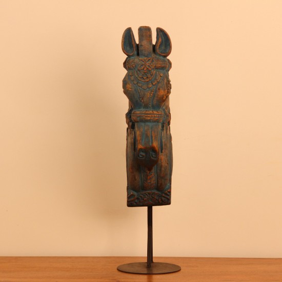 Blue distressed carved wooden horse on stand styled on a wooden table as table décor