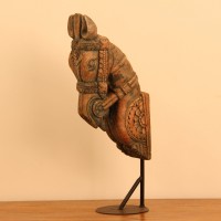 Green and natural wood distressed carved horse on stand styled on a wooden table as table décor