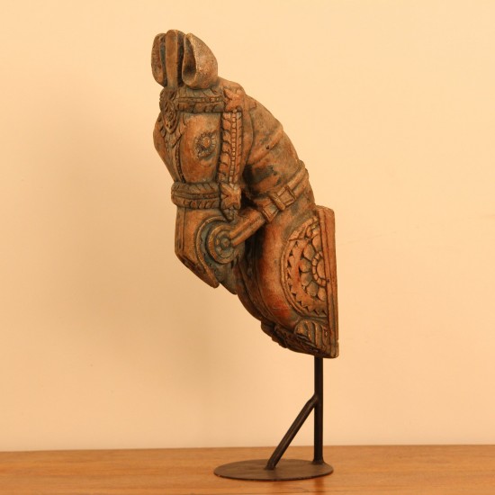 Green and natural wood distressed carved horse on stand styled on a wooden table as table décor