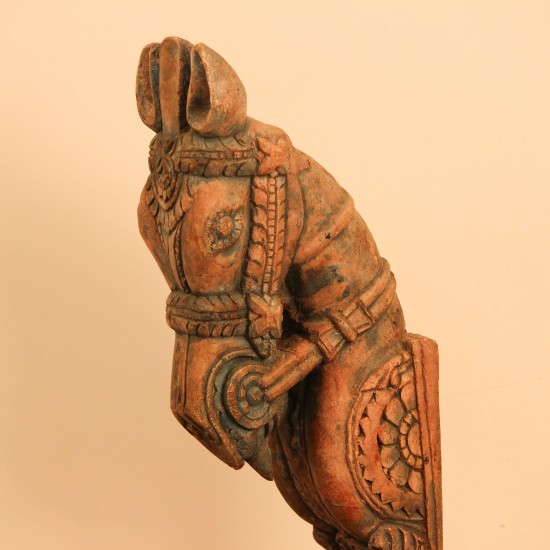 Green and natural wood distressed carved horse on stand styled on a wooden table as table décor
