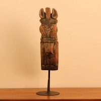 Green and natural wood distressed carved horse on stand styled on a wooden table as table décor