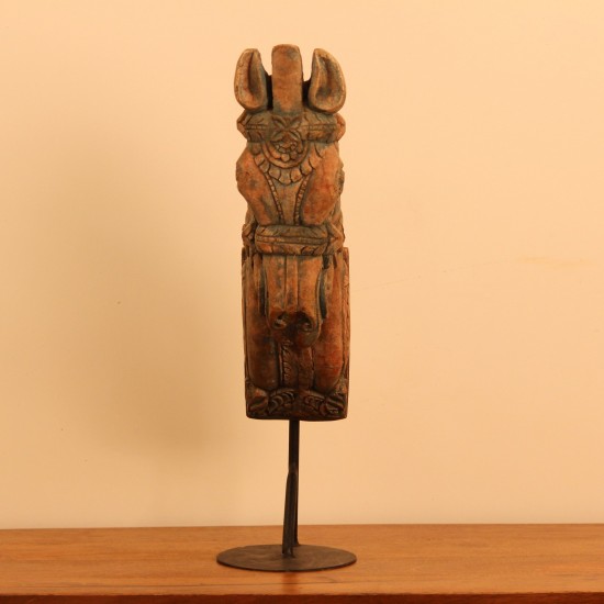 Green and natural wood distressed carved horse on stand styled on a wooden table as table décor