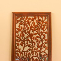 Sagwan wood leaf engraved wall mural hung on a warm wall above a console