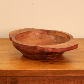 Small rustic red solid wood fruit bowl styled on a polished wooden console table
