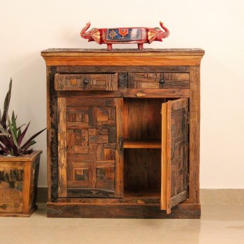 Reclaimed sleeper wood cabinet styled in a living room beside a plant, with a painted décor piece on top