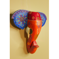 Hand-Painted Wooden Elephant Face Wall Decor in Blue and Orange – Indune Hand-painted wooden elephant face wall decor in blue and orange placed above a traditional Indian decor setup