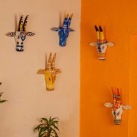  White and orange handpainted cow face wall decor featuring vibrant traditional Indian folk art patterns.