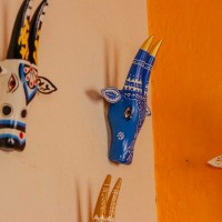 White base cow face wall decor with blue handpainted detailing in traditional Indian folk art style.