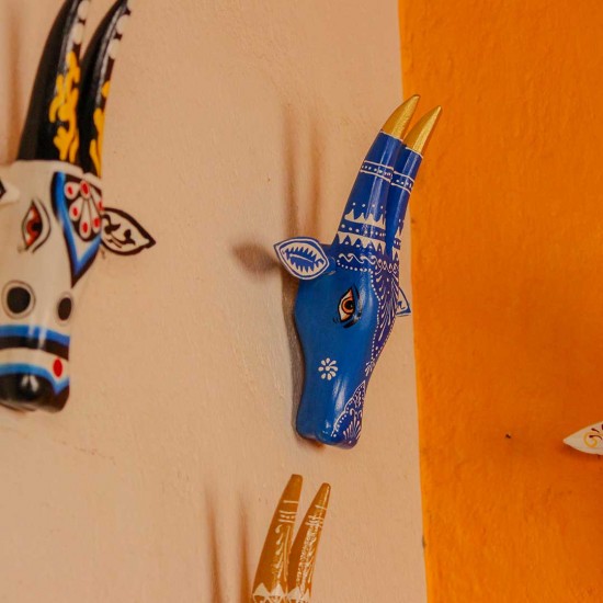 White base cow face wall decor with blue handpainted detailing in traditional Indian folk art style.