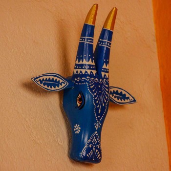 White base cow face wall decor with blue handpainted detailing in traditional Indian folk art style.